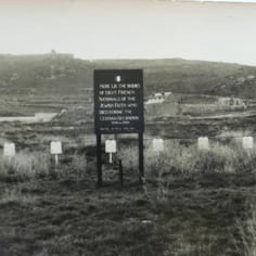 The Jewish Cemetery and graves at Longis Common, in a photograph taken at the end of the war and before the exhumation and removal of the Jewish remains.  The marker board was provided by the Allies.