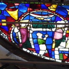 Dean's Eye Window - Scenes of St Hugh of Avalon Burial and 'Jewish' Stars (map, no. 3) -A scene from the Dean's Eye Window believed to show Bishop Hugh's funeral. One of the kingly pall-bearers (left) is black and may reference the story of the Jews  following  the Bishop's body, or the Black Magus.