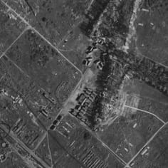This war-time photograph appears to show the Etaples camp (or Lager Erika).  The double row of huts just below centre of the photograph (identified by JTrails) matches the ground level photograph of Lager Erika and its back ground.