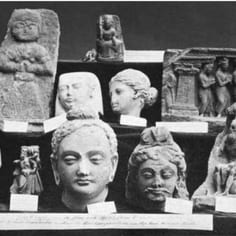 An important photograph of part of Leitner's original 'wandering collection' of Gandharan art, on display at an exhibition, with simple hand-written labels.